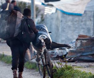 epa07416543 A migrant pushes his bicycle in the shantytown of San Ferdinando (Reggio Calabria), Italy, 06 March 2019. The clearing operations of the San Ferdinando shantytown began on 06 March. Around 900 people will be transferred to reception centers.  EPA/MARCO COSTANTINO