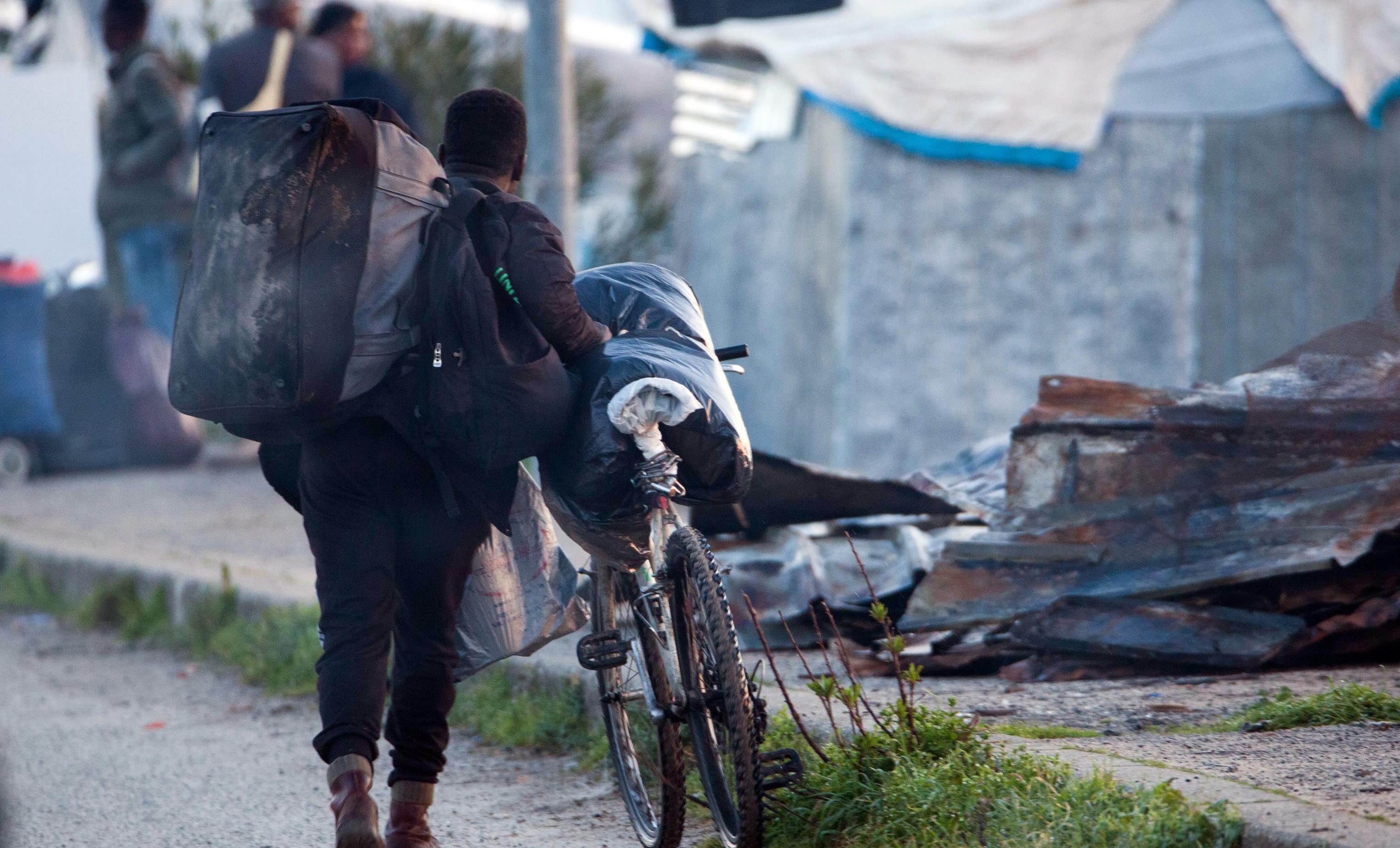 epa07416543 A migrant pushes his bicycle in the shantytown of San Ferdinando (Reggio Calabria), Italy, 06 March 2019. The clearing operations of the San Ferdinando shantytown began on 06 March. Around 900 people will be transferred to reception centers.  EPA/MARCO COSTANTINO