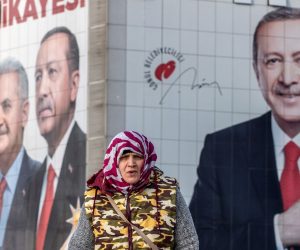 epa07467143 A woman walks in front of the pictures of Turkish President Recep Tayyip Erdogan (R) and Candidate of Justice and Development Party (AK Party) for Istanbul mayor Binali Yildirim (L), in Istanbul, Turkey, 27 March 2019. Local elections in Turkey's capital and the country's overall 81 provinces are scheduled for 31 March 2019.  EPA/SEDAT SUNA
