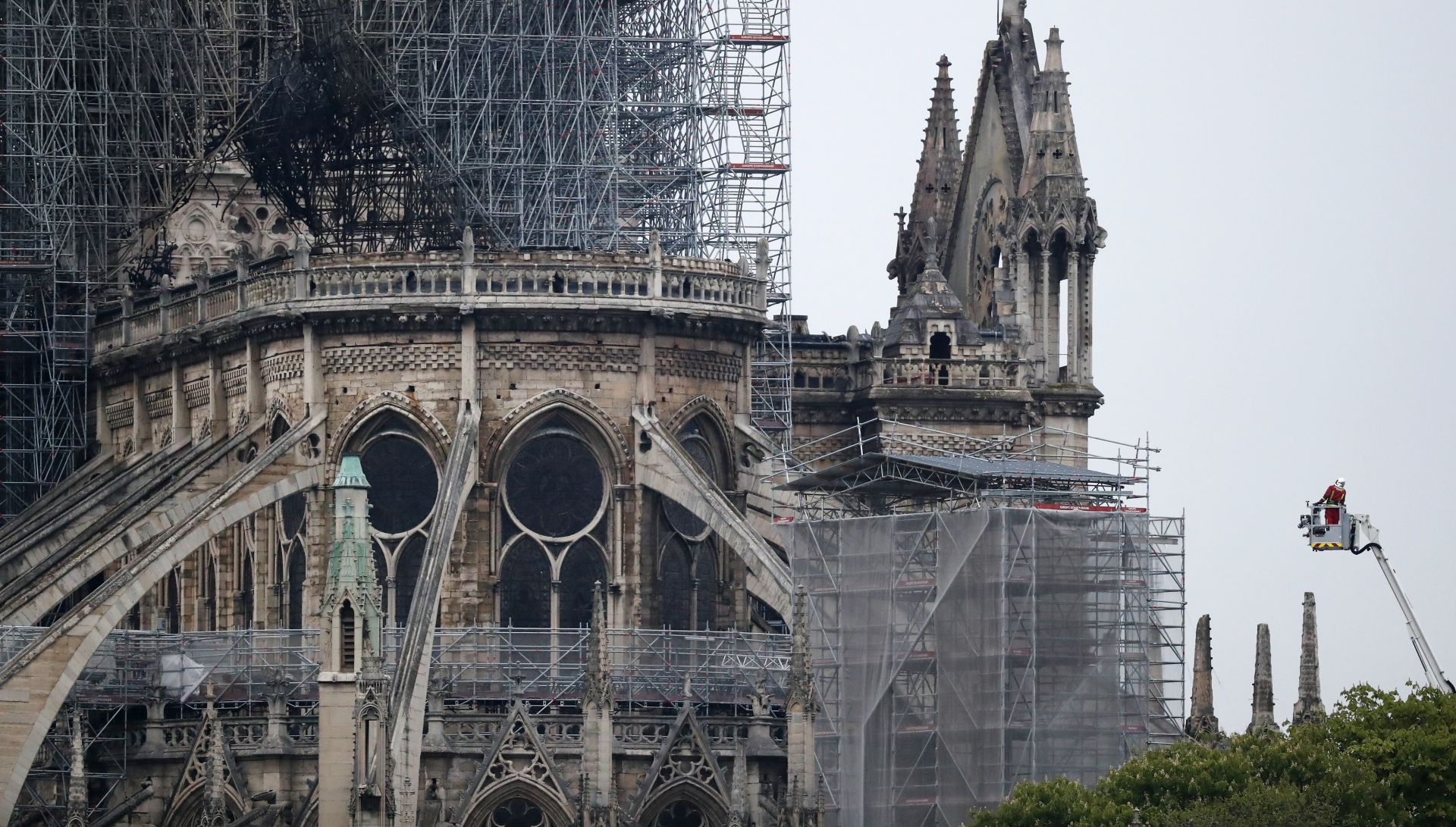 epa07509275 A firefighter stands in an aerial lift near the burnt roof after a massive fire destroyed the roof of the Notre-Dame Cathedral in Paris, France, 16 April 2019. A fire started in the late afternoon on 15 April in one of the most visited monuments of the French capital.  EPA/IAN LANGSDON