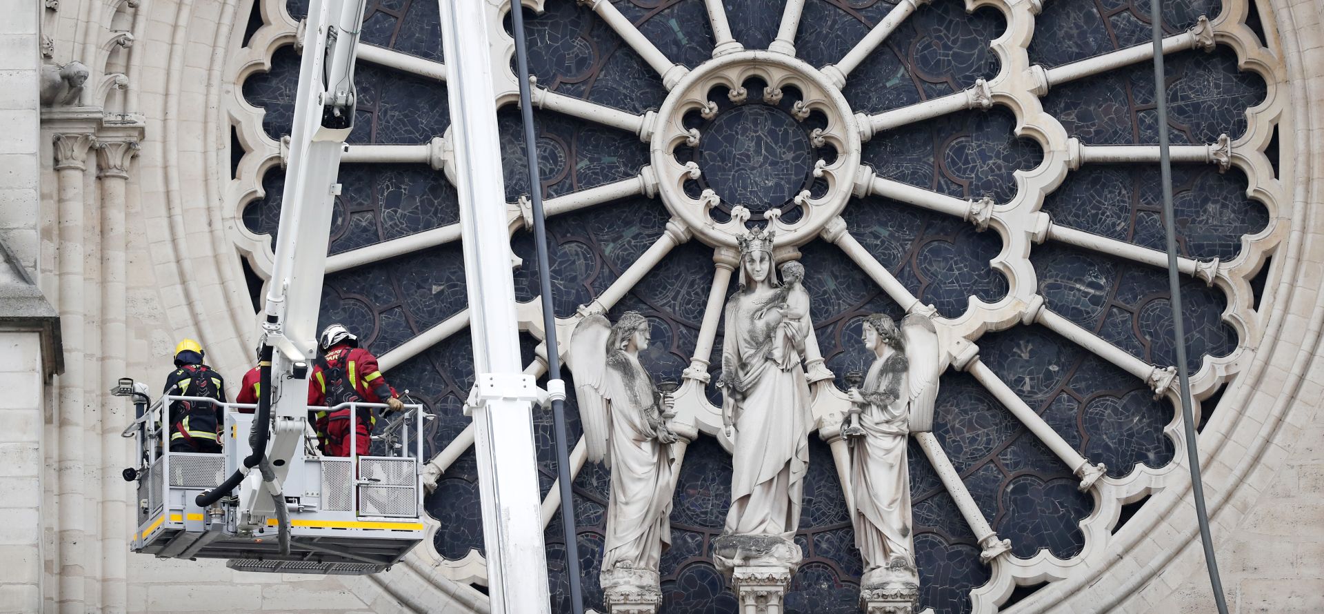 epa07509392 Fire fighters stand in an aerial lift after a massive fire destroyed the roof of the Notre-Dame Cathedral in Paris, France, 16 April 2019. A fire started in the late afternoon 15 April in one of the most visited monuments of the French capital.  EPA/IAN LANGSDON