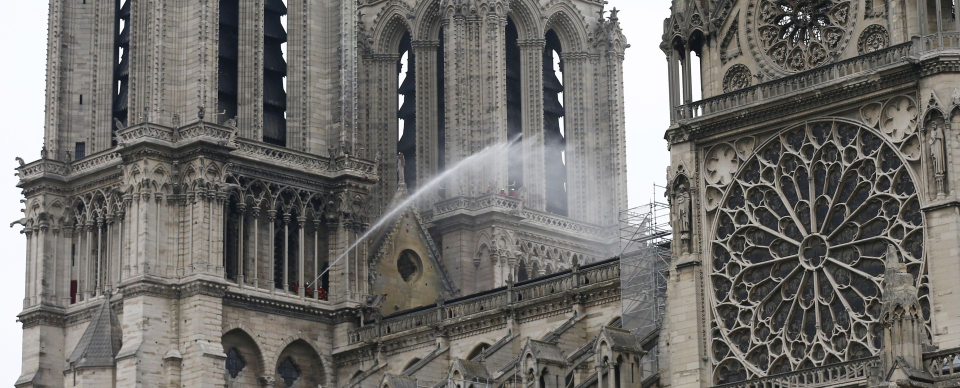 epa07510403 Fire fighters continue to spray water after a massive fire destroyed the roof of the Notre-Dame Cathedral in Paris, France, 16 April 2019. A fire started in the late afternoon 15 April in one of the most visited monuments of the French capital.  EPA/IAN LANGSDON