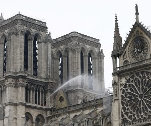 epa07510403 Fire fighters continue to spray water after a massive fire destroyed the roof of the Notre-Dame Cathedral in Paris, France, 16 April 2019. A fire started in the late afternoon 15 April in one of the most visited monuments of the French capital.  EPA/IAN LANGSDON