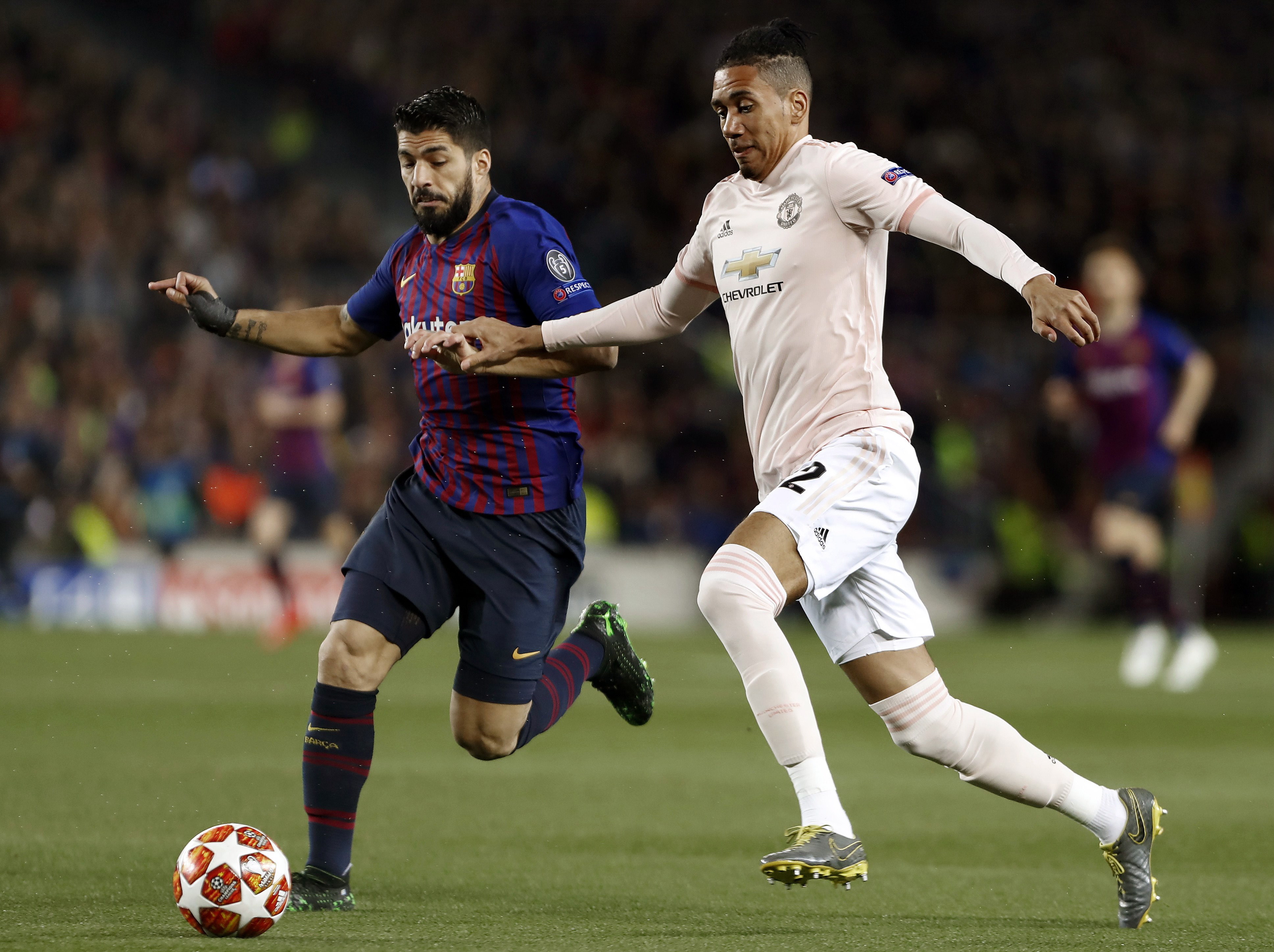 epa07510788 FC Barcelona's forward Luis Suarez (L) vies for the ball against Manchester United's defender Chris Smalling (R) during the UEFA Champions League quarter-final second leg match between FC Barcelona and Manchester United at Camp Nou stadium in Barcelona, Catalonia, Spain, 16 April 2019.  EPA/Andreu Dalmau