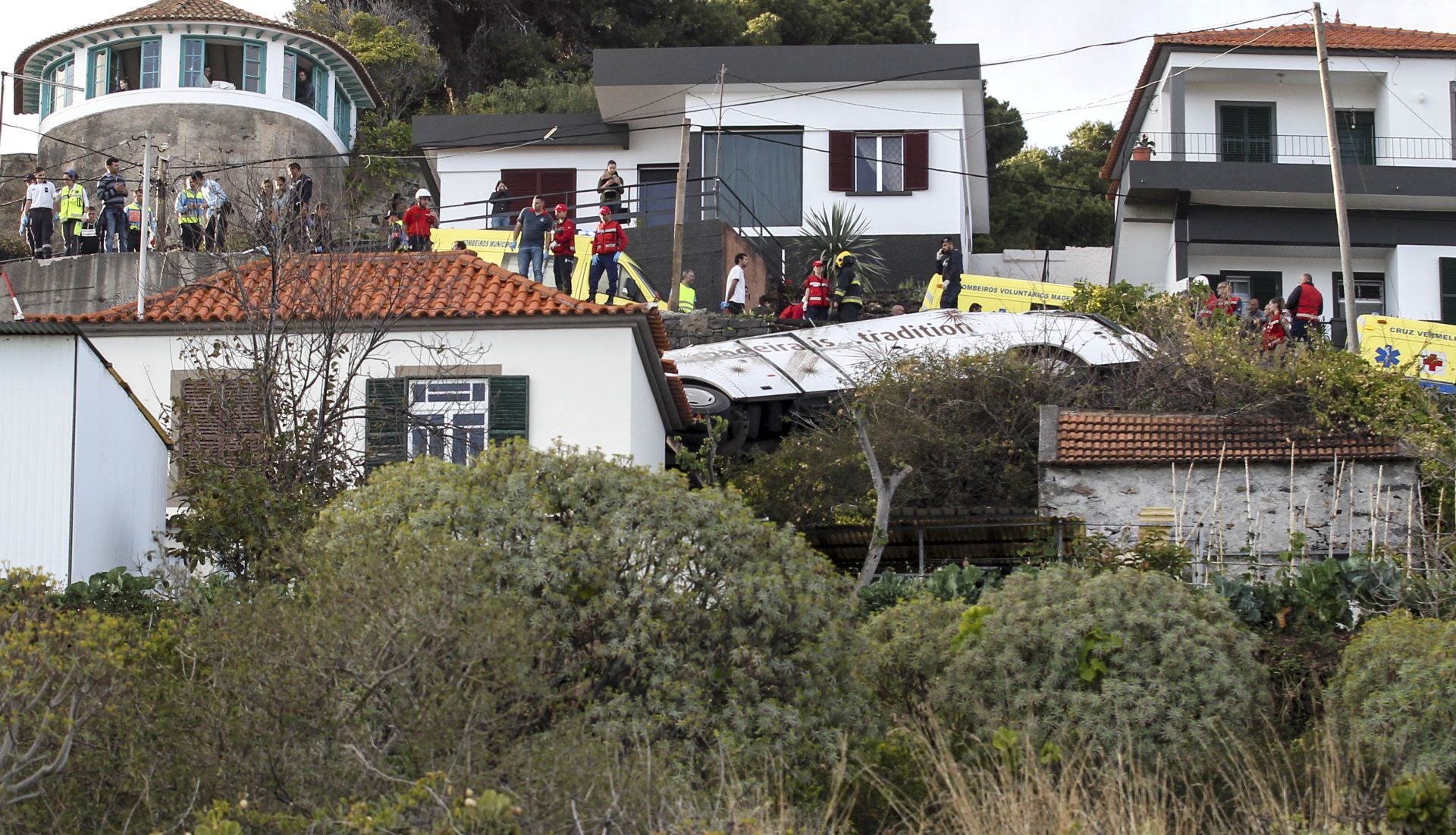 epa07512747 Emergency services inspect the scene of a tourist bus crash in Canico, Santa Cruz, Madeira Island, Portugal, 17 April 2019. According the Civil Protection of Madeira, several people died in the accident.  EPA/HOMEM GOUVEIA