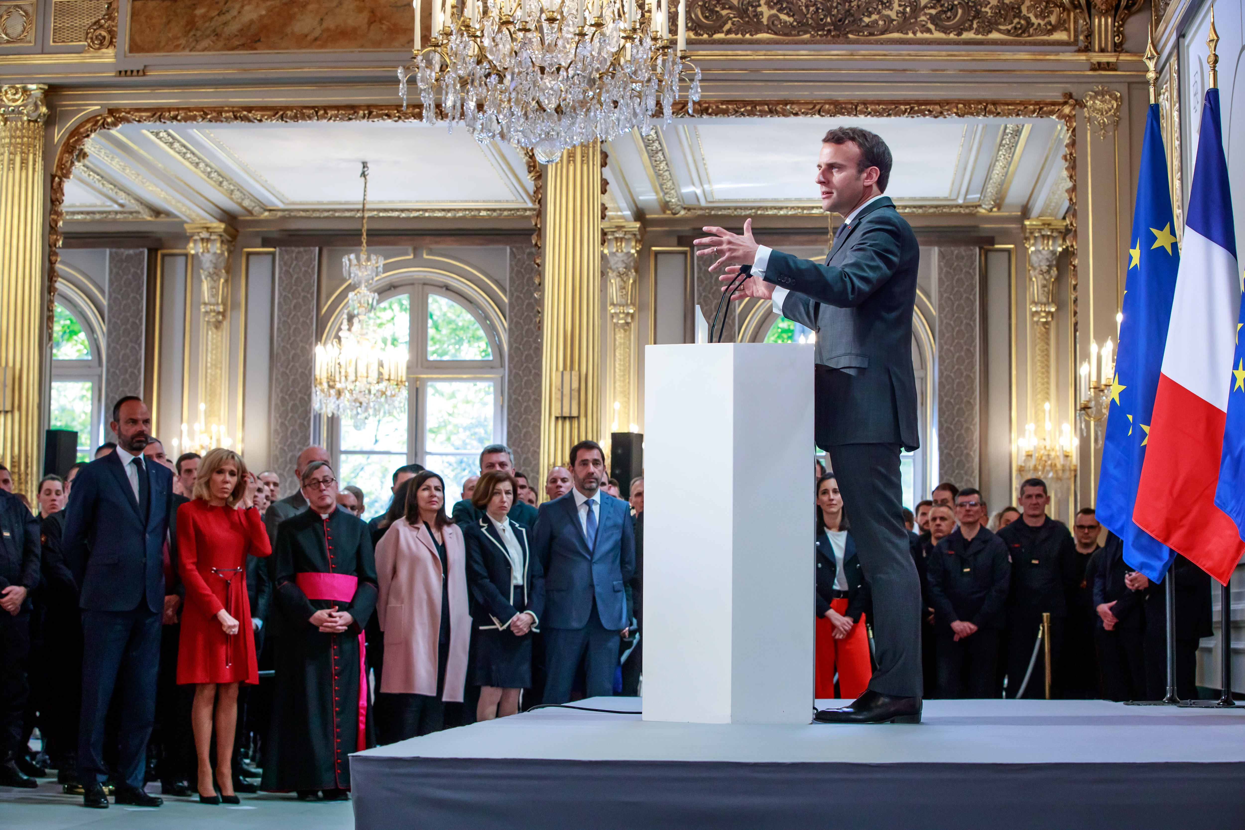 epa07513802 French President Emmanuel Macron (C) delivers a speech for the Parisian Firefighters' brigade and security forces who took part at the fire extinguishing operations during the Notre Dame of Paris Cathedral fire, at Elysee Palace in Paris, France, 18 April 2019. A fire of which cause is still not established, ravaged Notre Dame of Paris Cathedral, one of the most visited monuments of the French capital, on 15 April.  EPA/CHRISTOPHE PETIT TESSON / POOL