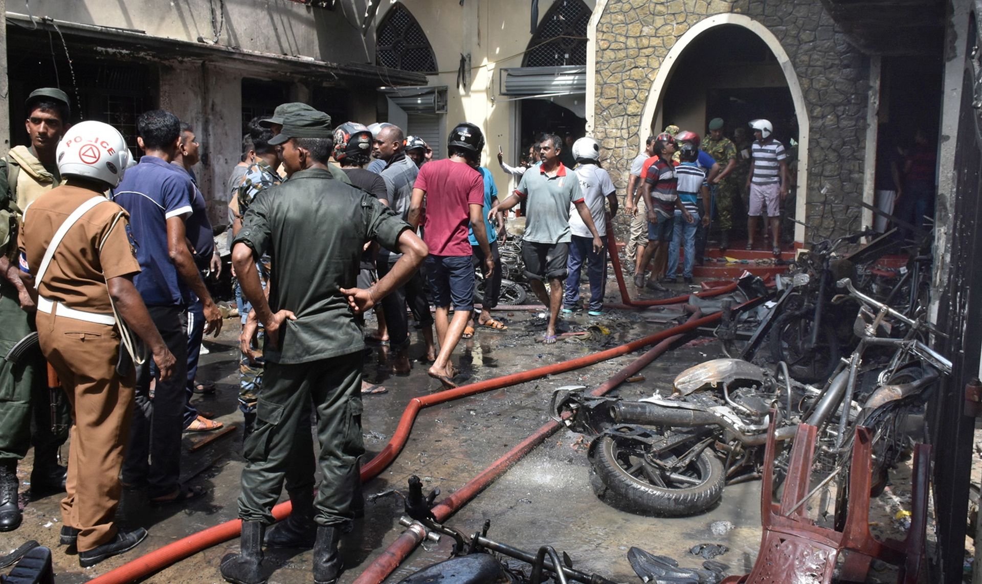 epa07518955 Locals and police gather at the Secon church Batticalova central road in Colombo, Sri Lanka, 21 April 2019. According to the news reports at least 138 people killed and over 400 injured in a series of blasts during the Easter Sunday service at St Anthony's Church in Kochchikade, Shangri-La Hotel and Kingsbury Hotel with many more places.  EPA/M.A. PUSHPA KUMARA