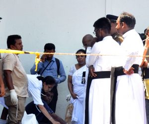 epa07519598 Policemen and priests look on as rescue workers evacuate remains of victims at the scene after an explosion hit at St Anthony's Church in Kochchikade in Colombo, Sri Lanka, 21 April 2019. According to news reports at least 138 people killed and over 400 injured in a series of blasts during the Easter Sunday service at St Anthony's Church in Kochchikade, Shangri-La Hotel and Kingsbury Hotel with many more places. EPA/M.A. PUSHPA KUMARA