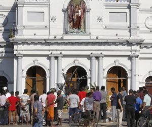 epa07520941 Sri Lankan people stand outside St. Anthony's Church in Kochchikade, Colombo, Sri Lanka, 22 April 2019. According to news reports, at least 290 people have been killed and over 500 injured in a series of blasts during Easter Sunday service at churches and hotels across Colombo on 21 April.   EPA/M.A. PUSHPA KUMARA