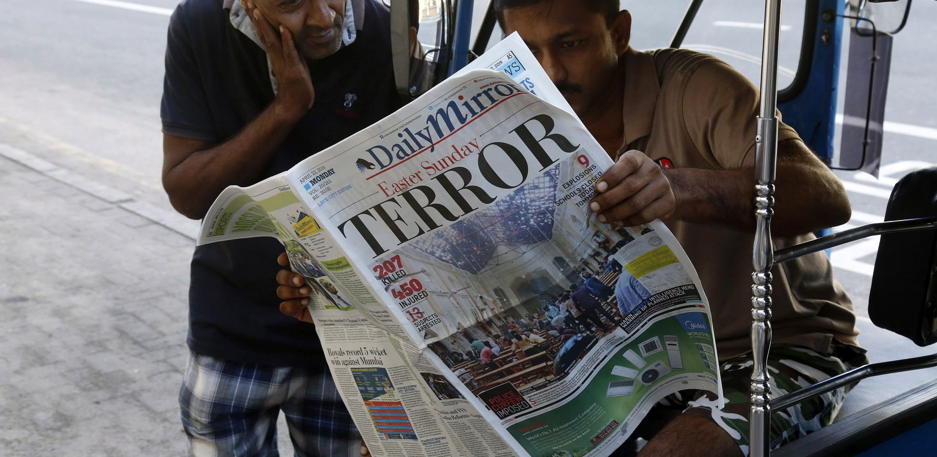 epa07520824 People read a newspaper the day after multiple blasts killed hundreds in Colombo, Sri Lanka, 22 April 2019. According to news reports, at least 290 people have been killed and over 500 were injured on 21 April 2019 in a series of blasts during Easter Sunday service at churches and hotels across Colombo.  EPA/M.A. PUSHPA KUMARA