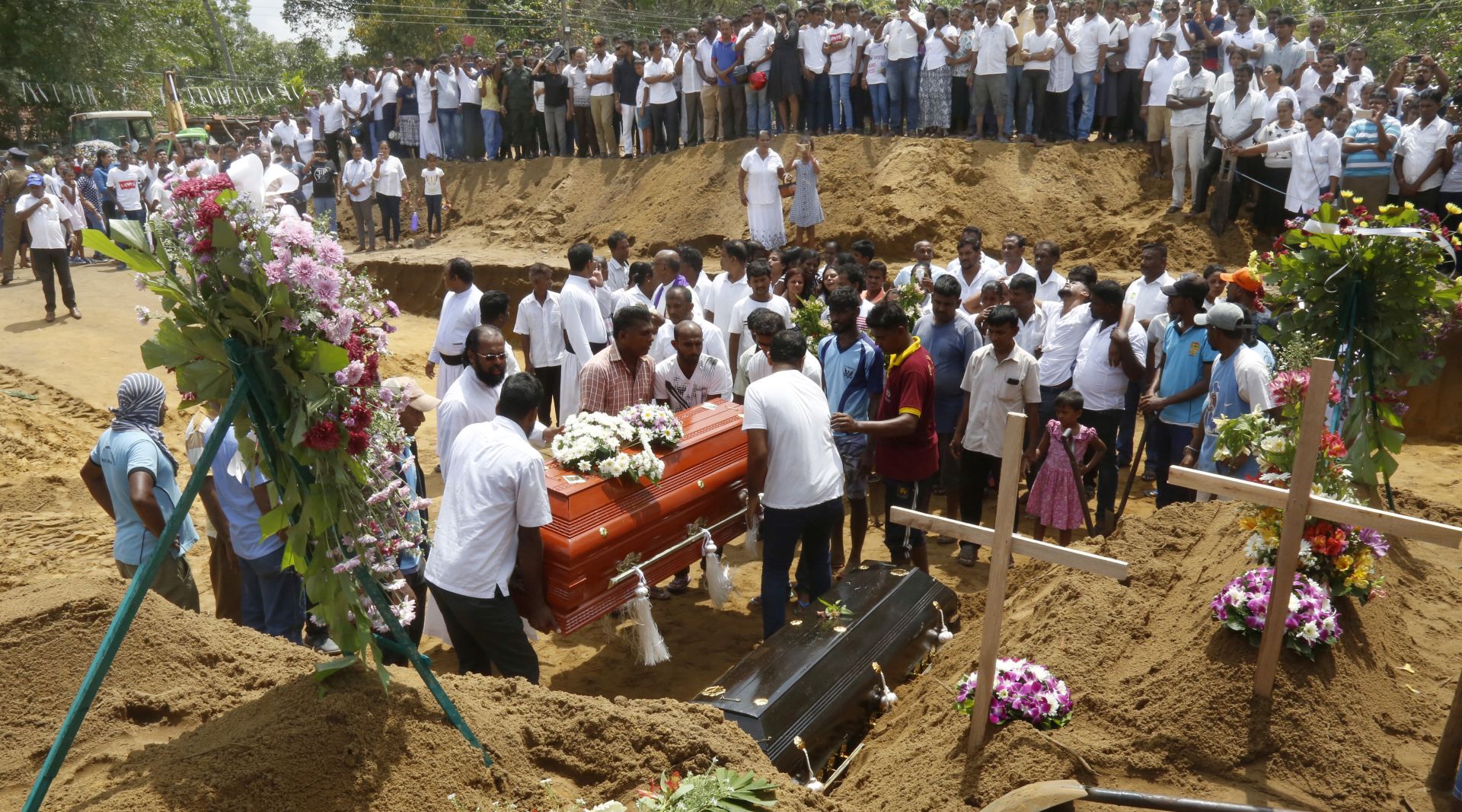epa07522390 Relatives and friends bury the victims of a series of  bomb blasts at cemetery Don David Katuwapitiya in Colombo, Sri Lanka, 23 April 2019. According to police, at least 290 people were killed and more than 400 injured in a coordinated series of blasts during the Easter Sunday service at churches and hotels in Sri Lanka on 21 April 2019.  EPA/M.A. PUSHPA KUMARA