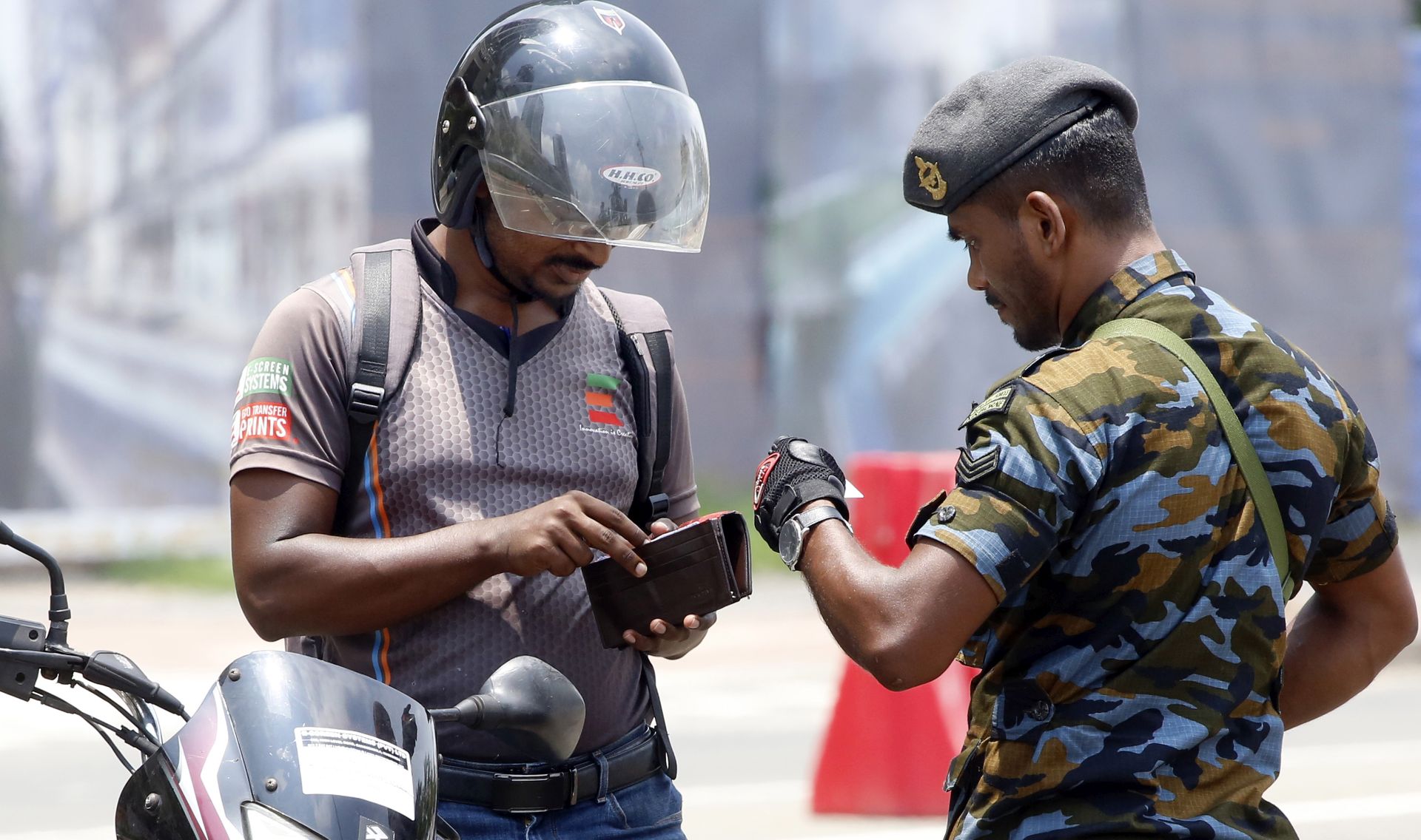epa07526913 A Sri Lankan security officer checks driver's identity proof in Colombo, Sri Lanka, 25 April 2019. According to the news reports, most public places have no people around as security agencies continue to find suspected bomb detonators after at least 320 people were killed in a coordinated series of blasts during the Easter Sunday service at churches and hotels in Sri Lanka on 21 April 2019.  EPA/M.A. PUSHPA KUMARA