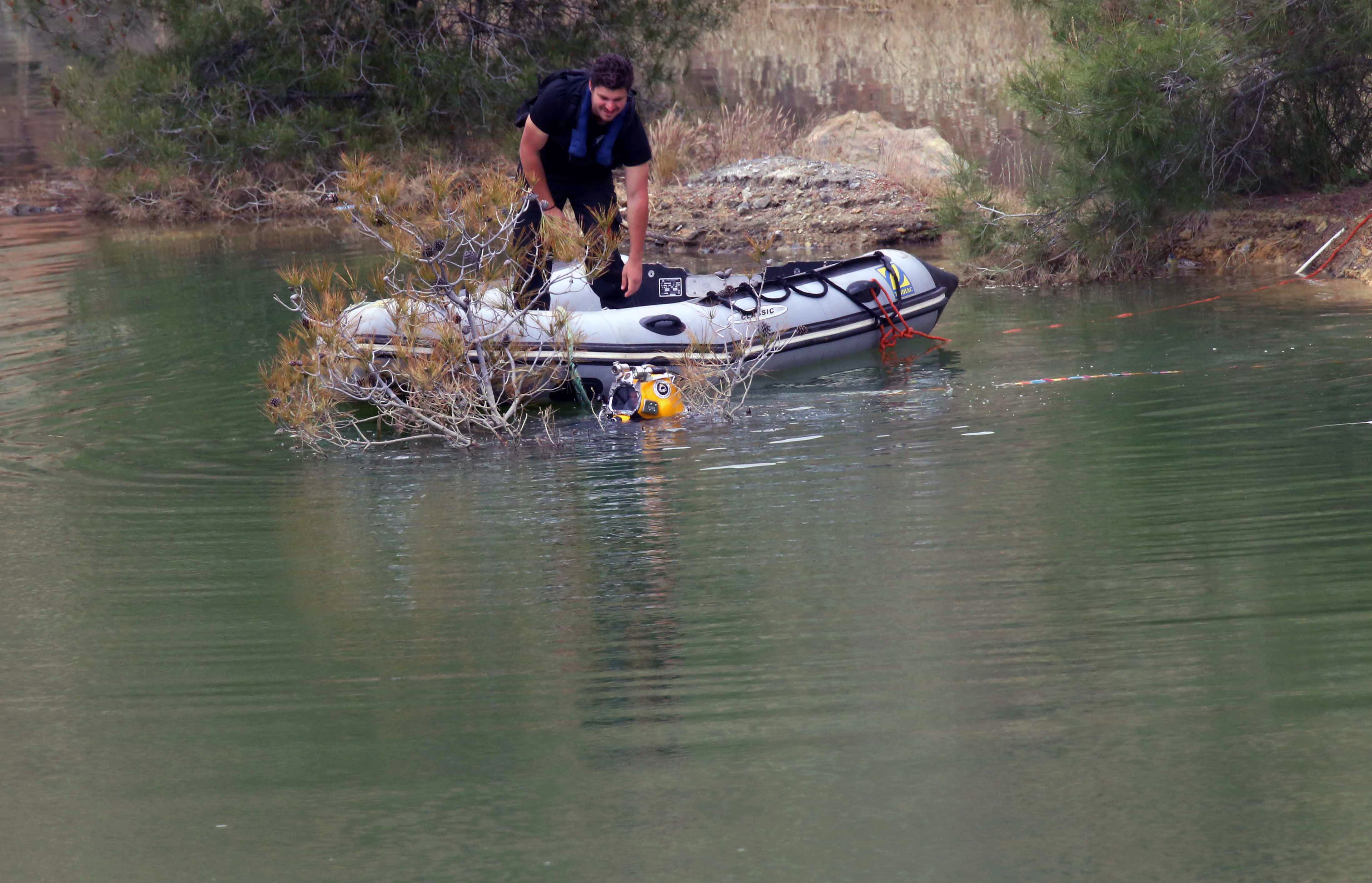 epa07530514 Firefighters and Investigators search the manmade lake near the village of Xiliato for the remains of more victims outside the Nicosia, Cyprus, 26 April 2019. Cyprus police is intensifying a search for the remains of more victims at locations where an army officer, who authorities say killed five women and two girls, had dumped their bodies.  EPA/KATIA CHRISTODOULOU