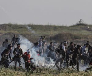 epa07516400 Palestinians protesters run for cover from Israeli tear-gas during clashes after Friday protests near the border between Israel and Gaza Strip, eastern Gaza Strip on, 19 April 2019. Palestinian protesters call for the right of Palestinian refugees across the Middle East to return to homes they fled in the war surrounding the 1948 creation of Israel.  EPA/MOHAMMED SABER
