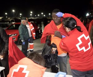 epa07577503 A sub-Saharan migrant (C) is assisted by a Spanish Red Cross member upon his arrival at the port after they were rescued by Spanish authorities in Motril, Granada, southern Spain, early 17 May 2019. Spanish Sea Rescue unit intercepted a boat with 56 migrants on board 50 miles off Granada coast.  EPA/MIGUEL PAQUET