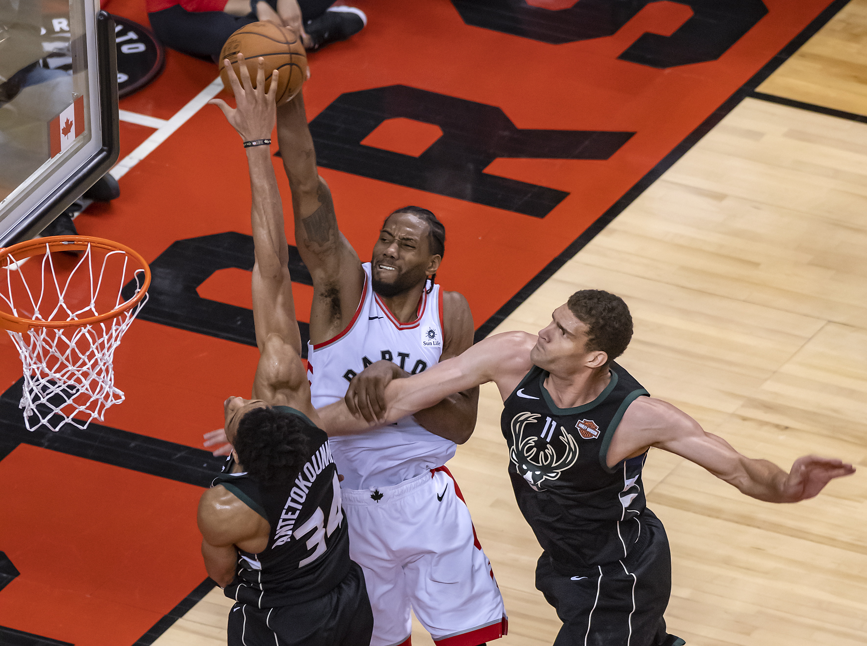 epa07601185 Toronto Raptors forward Kawhi Leonard (C) goes up to the basket between Milwaukee Bucks forward Giannis Antetokounmpo of Greece (L) and center Brook Lopez (R) in the fourth quarter of the NBA Eastern Conference Finals basketball game six between the Toronto Raptors and Milwaukee Bucks at Scotiabank Arena in Toronto, Canada, 25 May 2019.  EPA/WARREN TODA  SHUTTERSTOCK OUT