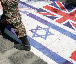epa07614657 An Iranian soldier walks on Britain and Israel flags during an anti-Israel rally mark Al Quds Day (Jerusalem Day), in support of Palestinian resistance against on the Israeli occupation, in Tehran, Iran, 31 May 2019. Quds Day was started by the late Ayatollah Khomeini, founder of the Islamic Iranian republic, who called on the world's Muslims to show solidarity with Palestinians on the last Friday of the fasting month of Ramadan.  EPA/ABEDIN TAHERKENAREH