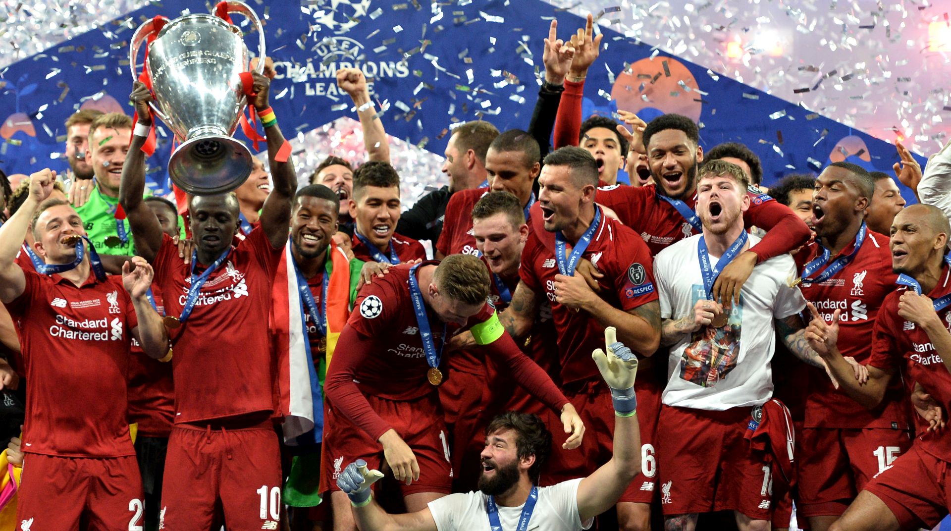 epa07619061 Players of Liverpool celebrate with the trophy after winning the UEFA Champions League final between Tottenham Hotspur and Liverpool FC at the Wanda Metropolitano stadium in Madrid, Spain, 01 June 2019.  EPA/PETER POWELL