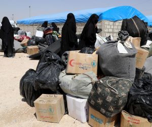 epa07623496 Wives of Islamic state fighters (IS) wait next to their belongings upon their deportation from the al-Hol camp for refugees in al-Hasakah governorate in northeastern Syria on 03 June 2019 (issued 04 June 2019).  According to media reports, the Kurdish authorities in northeast Syria are handing over 800 women and children all of them Syrian, including relatives of Islamic state fighters, to their families in the first such transfer from an overcrowded camp.  EPA/AHMED MARDNLI