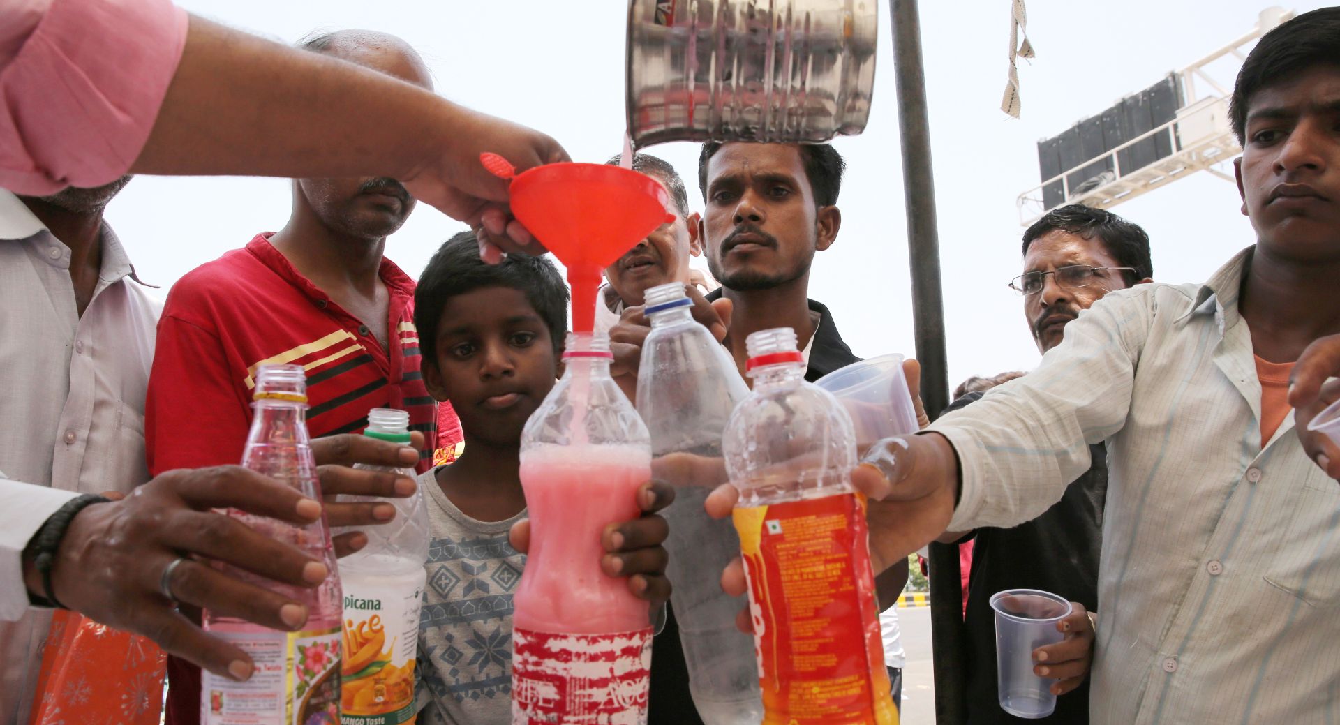 epa07631929 Indian volunteers offer sweet drinks to people on the occasion of the martyrdom day of the Guru Arjan Dev, the fifth Sikh Guru, on a hot day, in New Delhi, India, 07 June 2019. The region is witnessing intense heat wave conditions with peak temperature cross the 45 degrees Celsius.  EPA/RAJAT GUPTA
