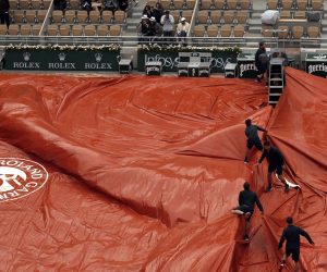 epa07633303 Staff covers the Court Philippe Chatrier as rain interrupts Dominic Thiem of Austria playing Novak Djokovic of Serbia during their men’s semi final match during the French Open tennis tournament at Roland Garros in Paris, France, 07 June 2019.  EPA/YOAN VALAT