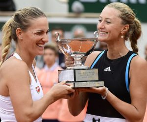 epa07636686 Timea Babos of Hungary (L) and Kristina Mladenovic of France pose with the trophy after winning the women’s doubles final match during the French Open tennis tournament at Roland Garros in Paris, France, 09 June 2019.  EPA/CAROLINE BLUMBERG