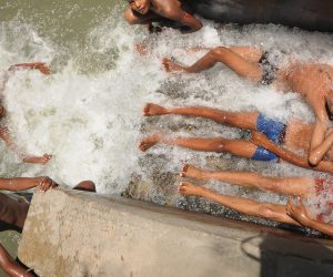 epa07638406 Indian boys cool off at a canal in New Delhi, India, 10 June 2019. The forecasts predict hot weather in the Indian capital with the maximum temperature at 46 degrees Celsius.   EPA/STR