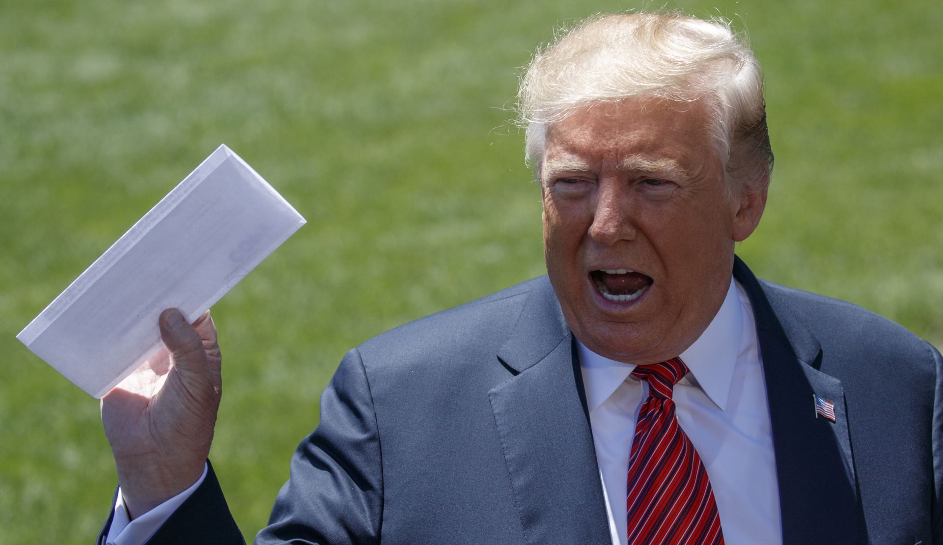 epa07641430 US President Donald J. Trump talks about a page from the USMCA as he responds to a question from the news media on the South Lawn of the White House in Washington, DC, USA, 11 June 2019. President Trump is traveling to Iowa to attend a renewable energy event and the Republican Party of Iowa annual dinner.  EPA/SHAWN THEW