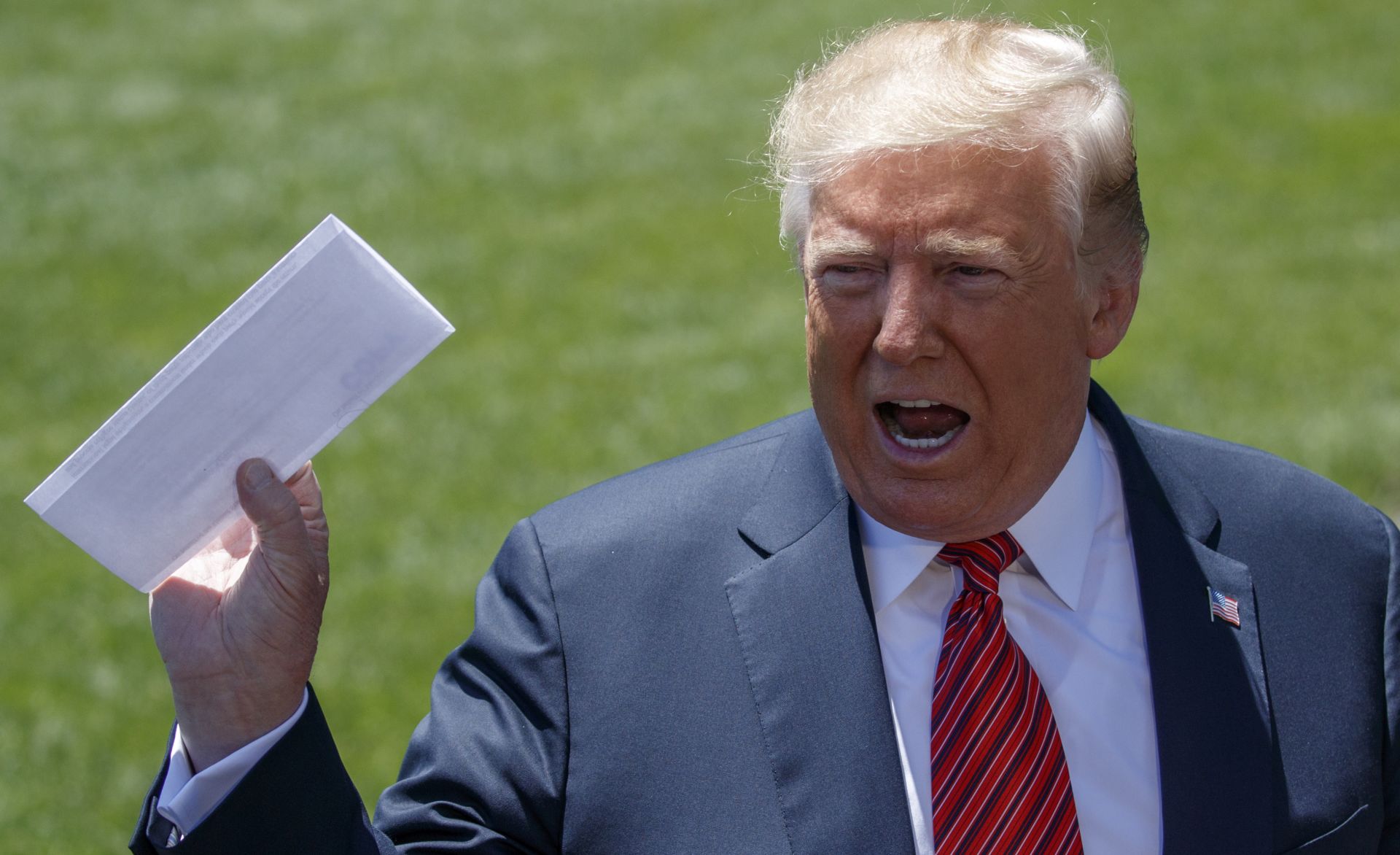 epa07641430 US President Donald J. Trump talks about a page from the USMCA as he responds to a question from the news media on the South Lawn of the White House in Washington, DC, USA, 11 June 2019. President Trump is traveling to Iowa to attend a renewable energy event and the Republican Party of Iowa annual dinner.  EPA/SHAWN THEW