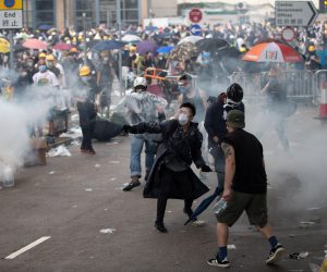 epa07643084 Protesters prepare to throw back tear gas at police during a rally against an extradition bill outside the Legislative Council in Hong Kong, China, 12 June 2019. The bill has faced immense opposition from pan-democrats, the business sector, and the international community, would allow the transfer of fugitives to jurisdictions which Hong Kong does not have a treaty with, including mainland China. Critics of the bill have expressed concern over unfair trials and a lack of human rights protection in mainland China.  EPA/JEROME FAVRE