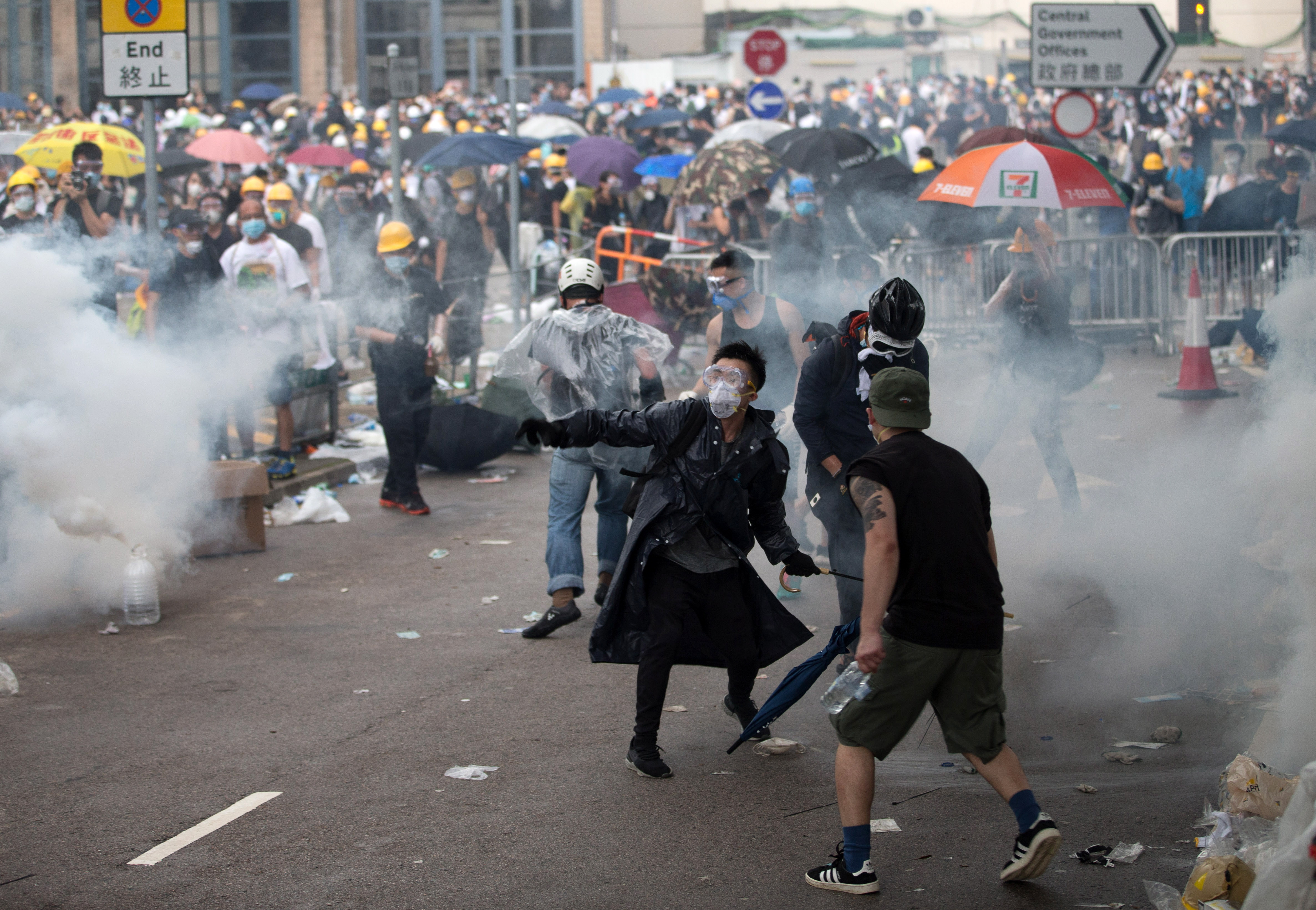 epa07643084 Protesters prepare to throw back tear gas at police during a rally against an extradition bill outside the Legislative Council in Hong Kong, China, 12 June 2019. The bill has faced immense opposition from pan-democrats, the business sector, and the international community, would allow the transfer of fugitives to jurisdictions which Hong Kong does not have a treaty with, including mainland China. Critics of the bill have expressed concern over unfair trials and a lack of human rights protection in mainland China.  EPA/JEROME FAVRE