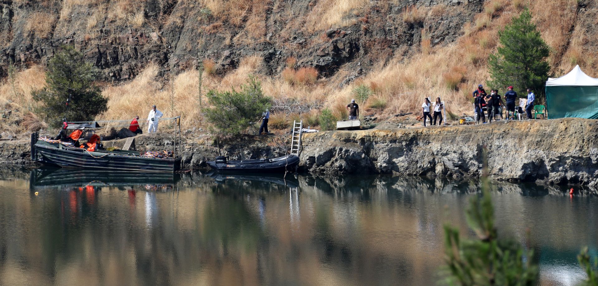 epa07643861 Cyprus police personnel carry a stretcher containing what is believed to be remains of a 6-year-old girl, near the village of Xiliatos, Cyprus, 12 June 2019. TA Cyprus police official says divers searching the bottom of a lake have discovered the remains of what authorities believe to be the remains of a 6-year-old girl that a serial killer has confessed to killing. The remains are thought to be the 7th and final victim of a 35-year-old Cyprus army captain.  EPA/KATIA CHRISTODOULOU
