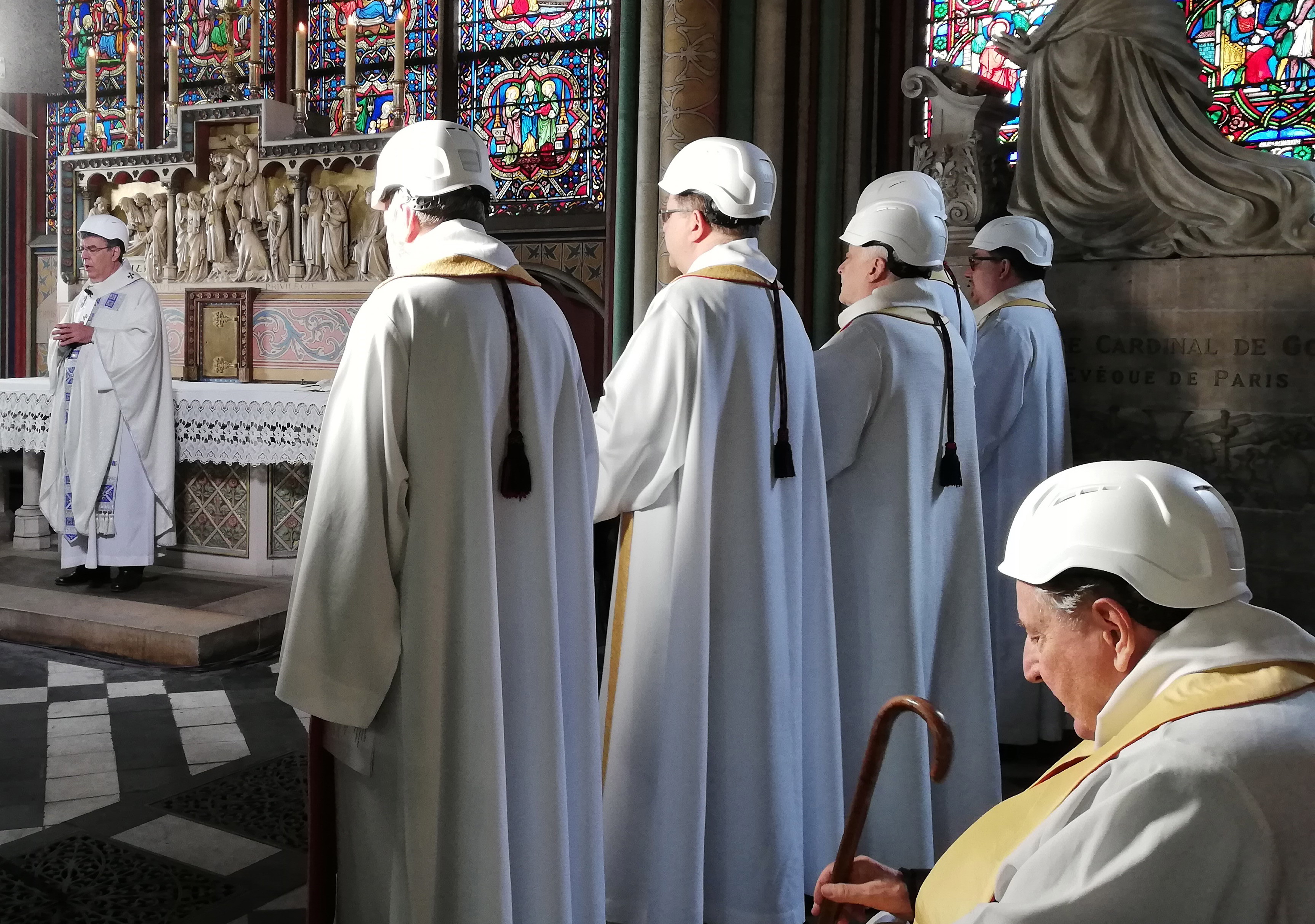 epa07650568 Clerics wear protective helmets as they attend a mass led by Michel Aupetit (L), Archbishop of Paris, which is the first church service in a side chapel of Notre-Dame de Paris cathedral in Paris, France, 15 June 2019, two months to the day after a devastating fire. For safety reasons, the mass was celebrated on a very small scale, but was streamed live on internet.  EPA/KARINE PERRET / POOL  MAXPPP OUT