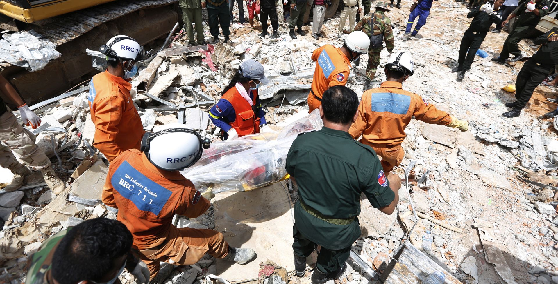 epa07667564 A Cambodian rescue team carries a worker's body at the site of a collapsed building on a construction site in Preah Sihanouk province, Cambodia, 23 June 2019. A new seven-storey building owned by a Chinese company, collapsed in Preah Sihanouk province, killing at least 18 workers and leaving 24 workers injured, according to reports.  EPA/KITH SEREY