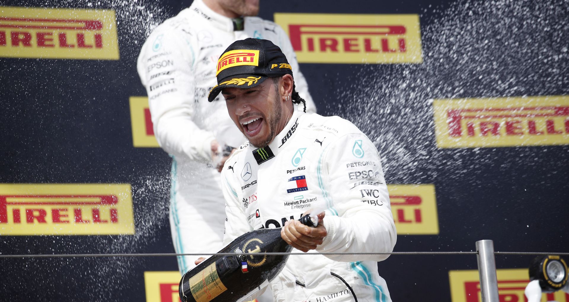 epa07668451 British Formula One driver Lewis Hamilton (front) of Mercedes AMG GP celebrates with his second placed Finnish teammate Valtteri Bottas (back) on the podium after winning the 2019 French Formula One Grand Prix at Paul Ricard circuit in Le Castellet, France, 23 June 2019.  EPA/YOAN VALAT