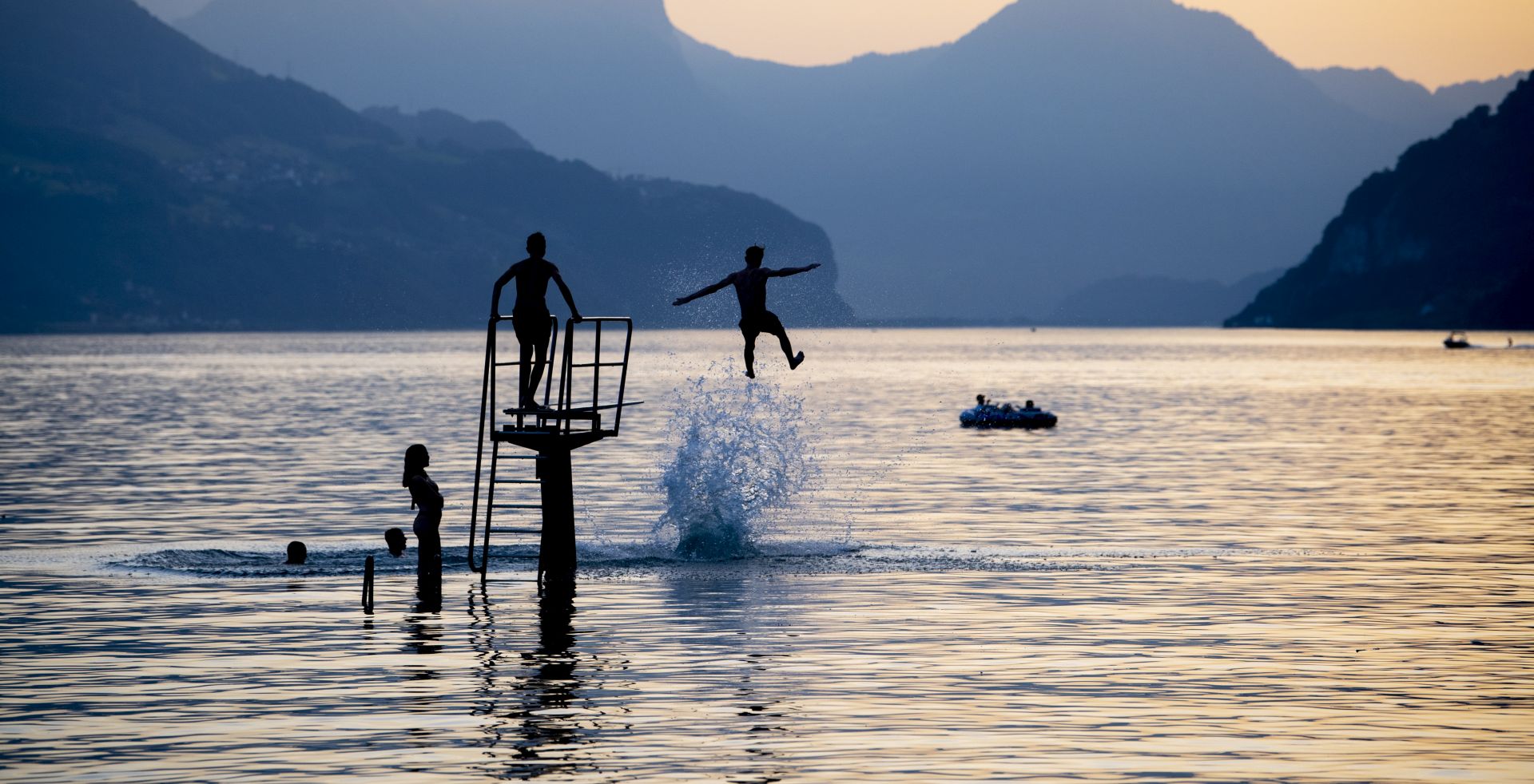 epa07673827 Youth enjoy the evening on lake Walensee in Walenstadt, Switzerland, 25 June 2019 (issued 26 June 2019). The country was hit by a heatwave with temperatures up to 39 degrees Celsius.  EPA/GIAN EHRENZELLER