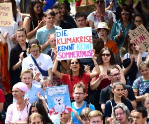 epa07679656 An activist holds a cardboard reading 'the climate crisis knows no summer break', during a 'Fridays for Future' demonstration in Berlin, Germany, 28 June 2019. The growing 'Fridays for Future' movement, which started in the summer of 2018, demands compliance with the goals of the Paris Agreement and the 1.5 degree Celsius target.  EPA/CLEMENS BILAN