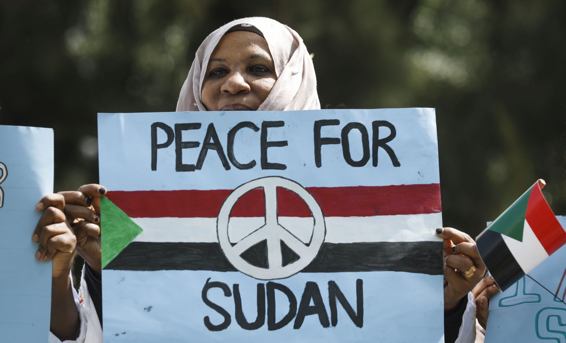 epa07657796 A Sudanese woman looks on with a placard during a protest against Sudan's crackdown on pro-democracy protesters, in Nairobi, Kenya, 19 June 2019. Some 100 people gathered in downtown Nairobi to mourn those who were killed by the Sudanese security forces in Khartoum on 03 June 2019. Kenyan police dispersed the gathering with tear gas.  EPA/DAI KUROKAWA