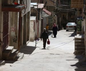 epa07673966 Palestinians walk on a street at the Balata refugee camp near the West Bank city of Nablus, 26 July 2019.  EPA/ALAA BADARNEH