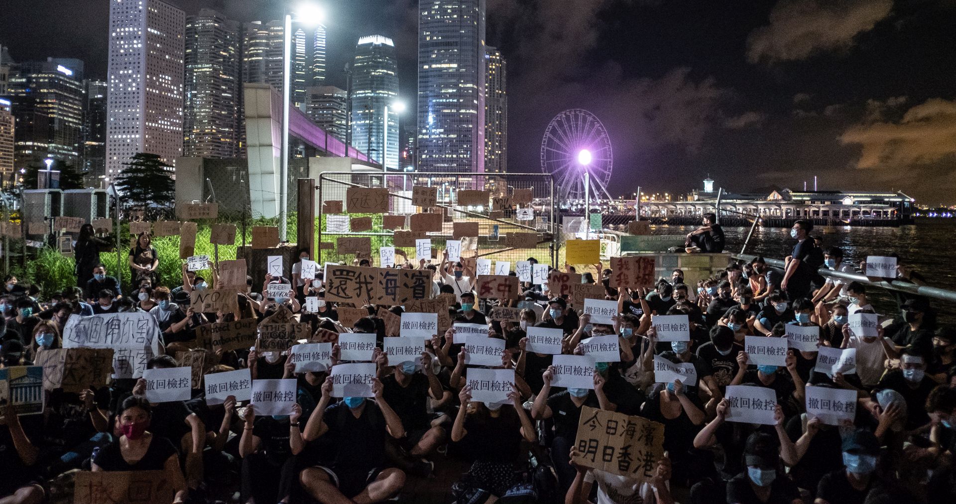 epa07681335 Protesters gather near a plot of land, which was just transferred to the People's Liberation Army (PLA), on the Victoria Harbour waterfront in Hong Kong, China, 29 June 2019. A group of anti-extradition bill protesters moved briefly onto a plot of land that automatically transferred to the PLA at midnight on Saturday. Police cleared the restricted site of protesters just minutes before the area was designated a dock of the PLA.  EPA/CHAN LONG HEI RESEND: LARGER FILE SIZE