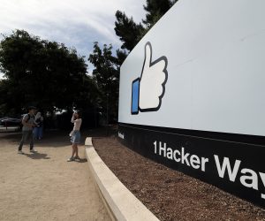 epa07688522 Facebook fans pose in front of a sign at Facebook Headquarters in Menlo Park, California, USA, 01 July 2019. According to reports, an investigation is taking place at the mailing facility of the Facebook Headquarters after a package was suspected of containing sarin poison, the buildings were evacuated.  EPA/JOHN G. MABANGLO