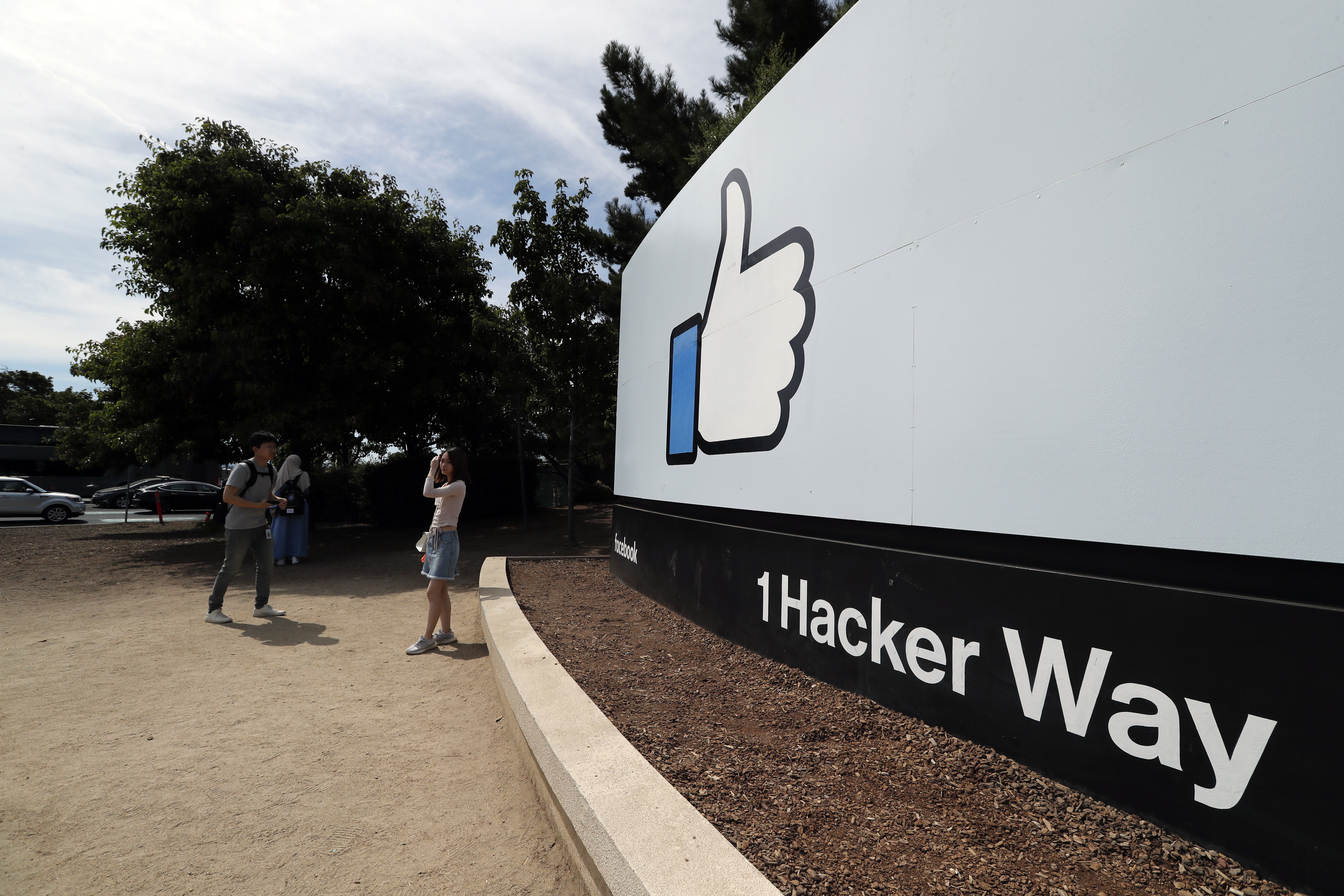 epa07688522 Facebook fans pose in front of a sign at Facebook Headquarters in Menlo Park, California, USA, 01 July 2019. According to reports, an investigation is taking place at the mailing facility of the Facebook Headquarters after a package was suspected of containing sarin poison, the buildings were evacuated.  EPA/JOHN G. MABANGLO