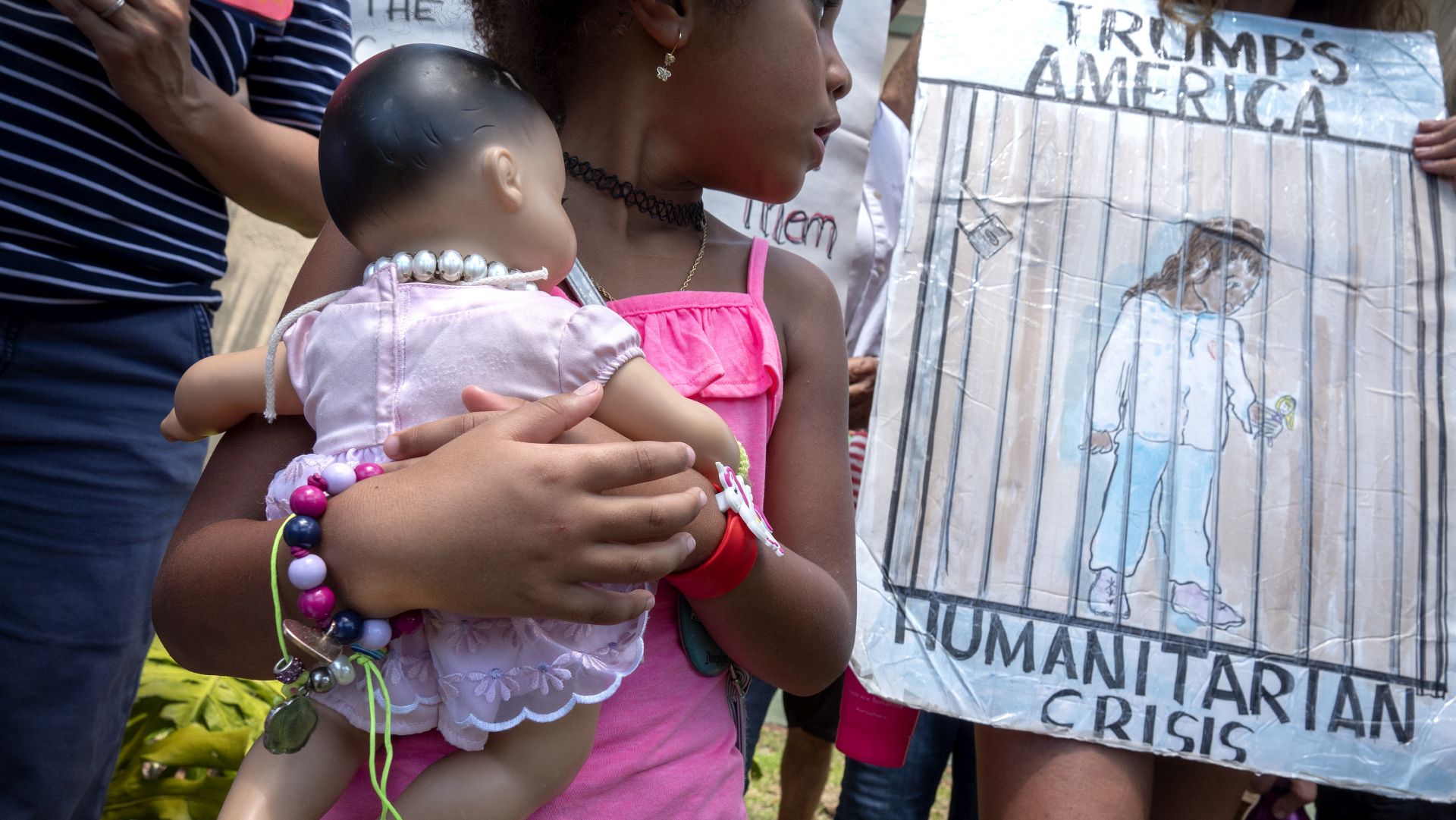 epa07690386 An unidentified girl carries a doll while she stands next to Immigration activists demanding the end of the migrant detention centers in the US, in front of Senator Marco Rubio's office building in Miami, Florida, USA, 02 July 2019. Over 170 demonstrations named #CloseTheCamps are taking place across the country, including cities like Miami, New York, Los Angeles and in border communities.  EPA/CRISTOBAL HERRERA