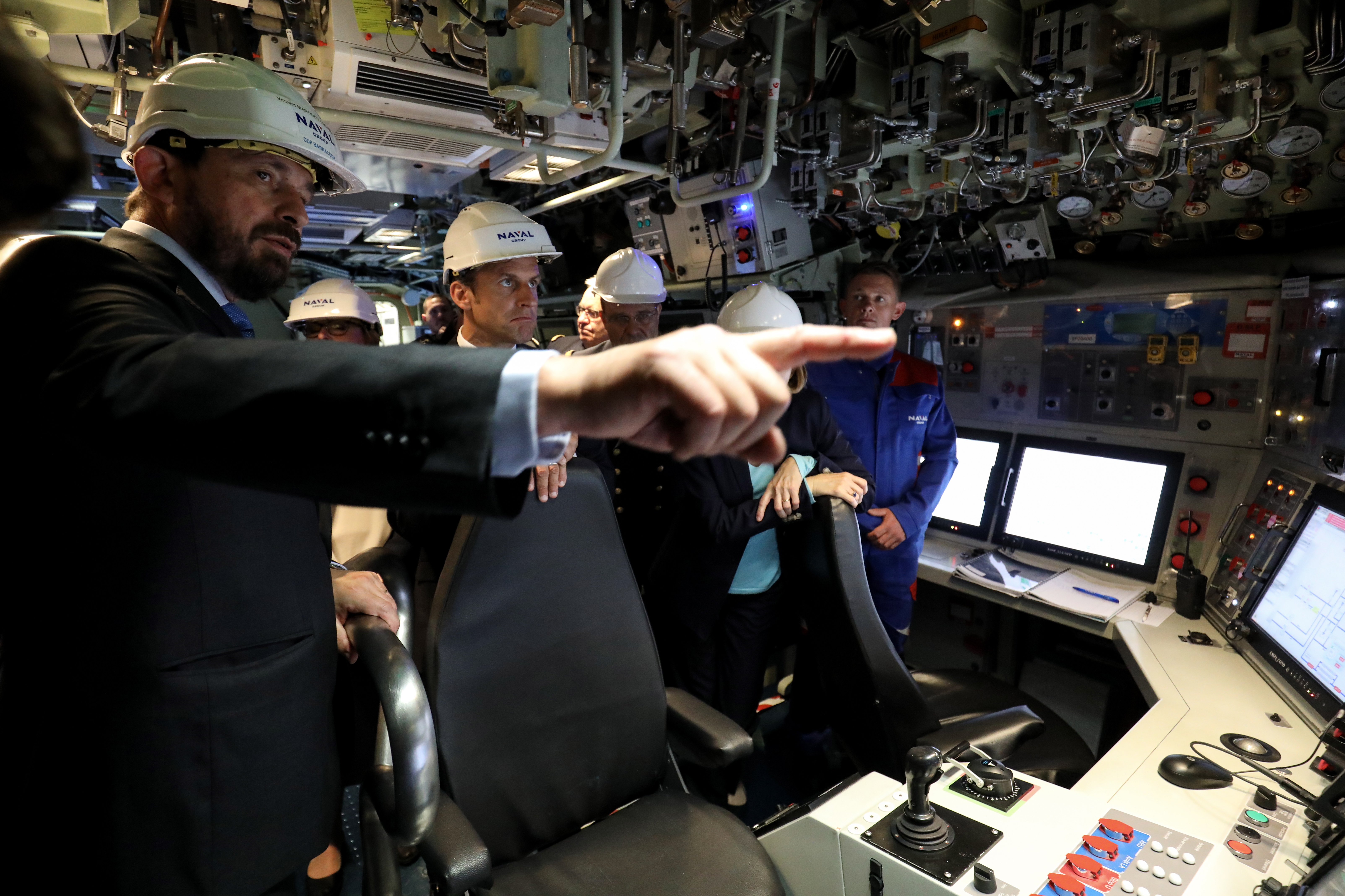 epa07711990 French President Emmanuel Macron (2-L) listens in the navigation and operations center during a visit of the new French nuclear submarine Suffren in Cherbourg, north-western France, 12 July 2019, as part of its official launch ceremony. The 99-metre-long black steel monster is named after Pierre-Andre Suffren, an admiral who distinguished himself against the English in the 18th century. The actual launch will only take place at the end of July, with a three-year delay, before dockside tests, then at sea, and its delivery to the French Navy in Toulon before summer 2020.  EPA/LUDOVIC MARIN / POOL  MAXPPP OUT