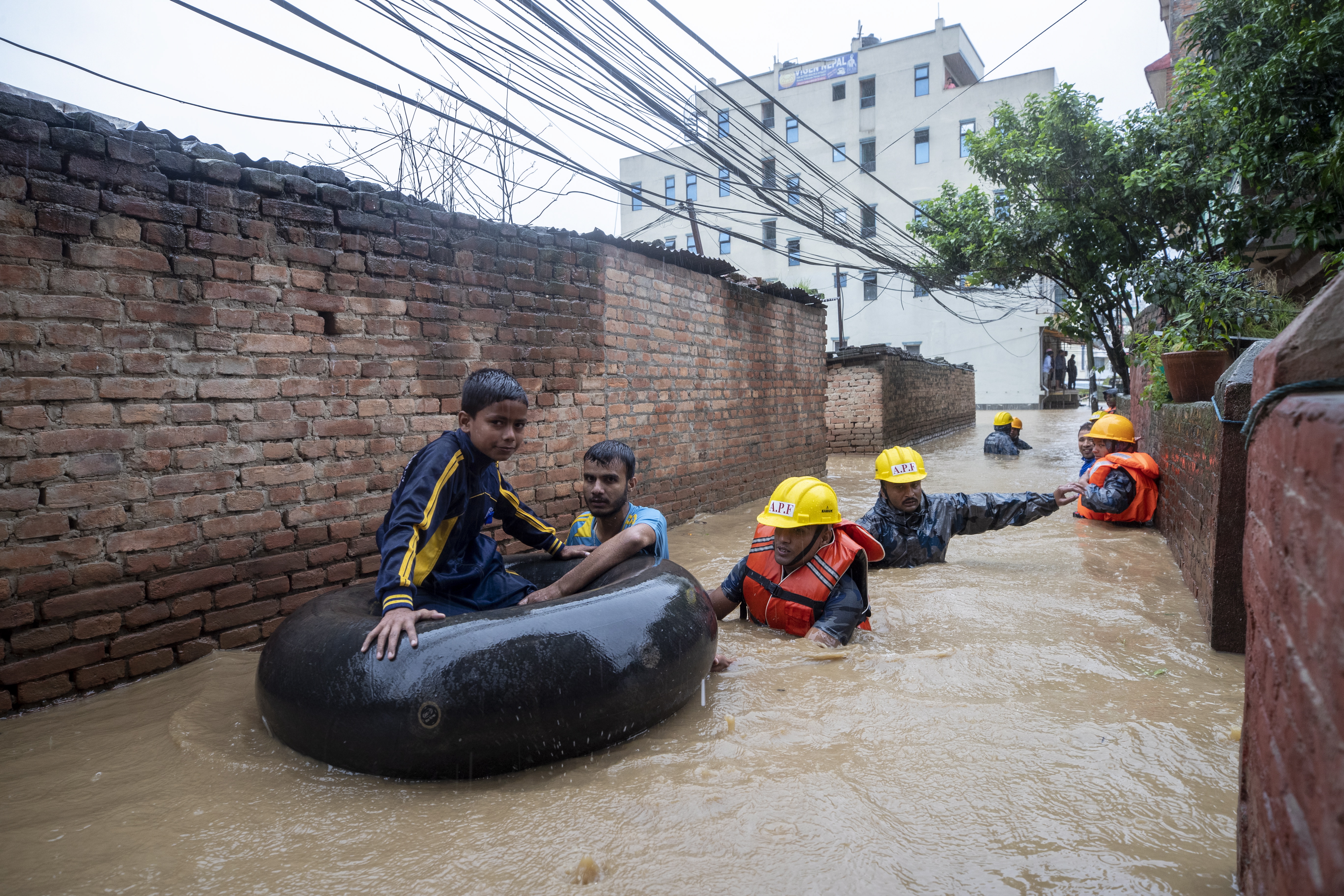 epa07712284 Members of armed police force rescue people from flooded houses following torrential rains in Kathmandu, Nepal, 12 July 2019. Meteorologists warned of heavy monsoon rains in Nepal that put several parts of the country at risk of floods and landslides.  EPA/NARENDRA SHRESTHA