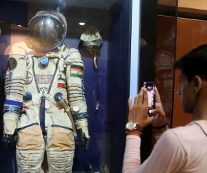 epa07714671 An Astronomy enthusiast takes the picture of a space suit displayed at Nehru Planetarium in New Delhi, India, 13 July 2019.  Chandrayaan-2 India's first moon lander and rover mission planned and developed by Indian Space Research Organisation (ISRO), named 'Vikram', and the robotic rover that explores the lunar surface named 'Pragyan' (wisdom) will be launched on the Moon by a Geosynchronous Satellite Launch Vehicle (GSLV) Mark III on 15 July 2019.  EPA/RAJAT GUPTA