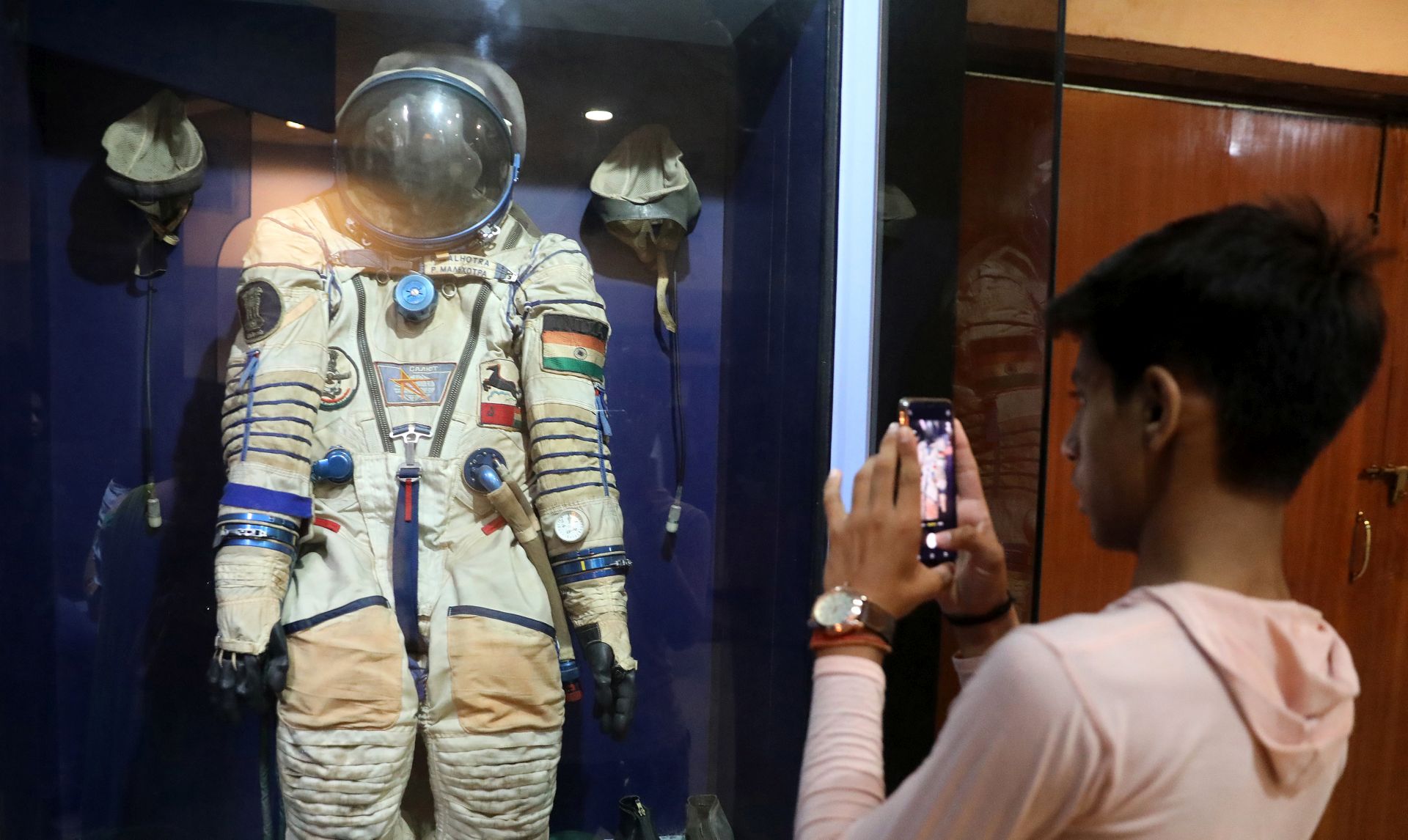 epa07714671 An Astronomy enthusiast takes the picture of a space suit displayed at Nehru Planetarium in New Delhi, India, 13 July 2019.  Chandrayaan-2 India's first moon lander and rover mission planned and developed by Indian Space Research Organisation (ISRO), named 'Vikram', and the robotic rover that explores the lunar surface named 'Pragyan' (wisdom) will be launched on the Moon by a Geosynchronous Satellite Launch Vehicle (GSLV) Mark III on 15 July 2019.  EPA/RAJAT GUPTA