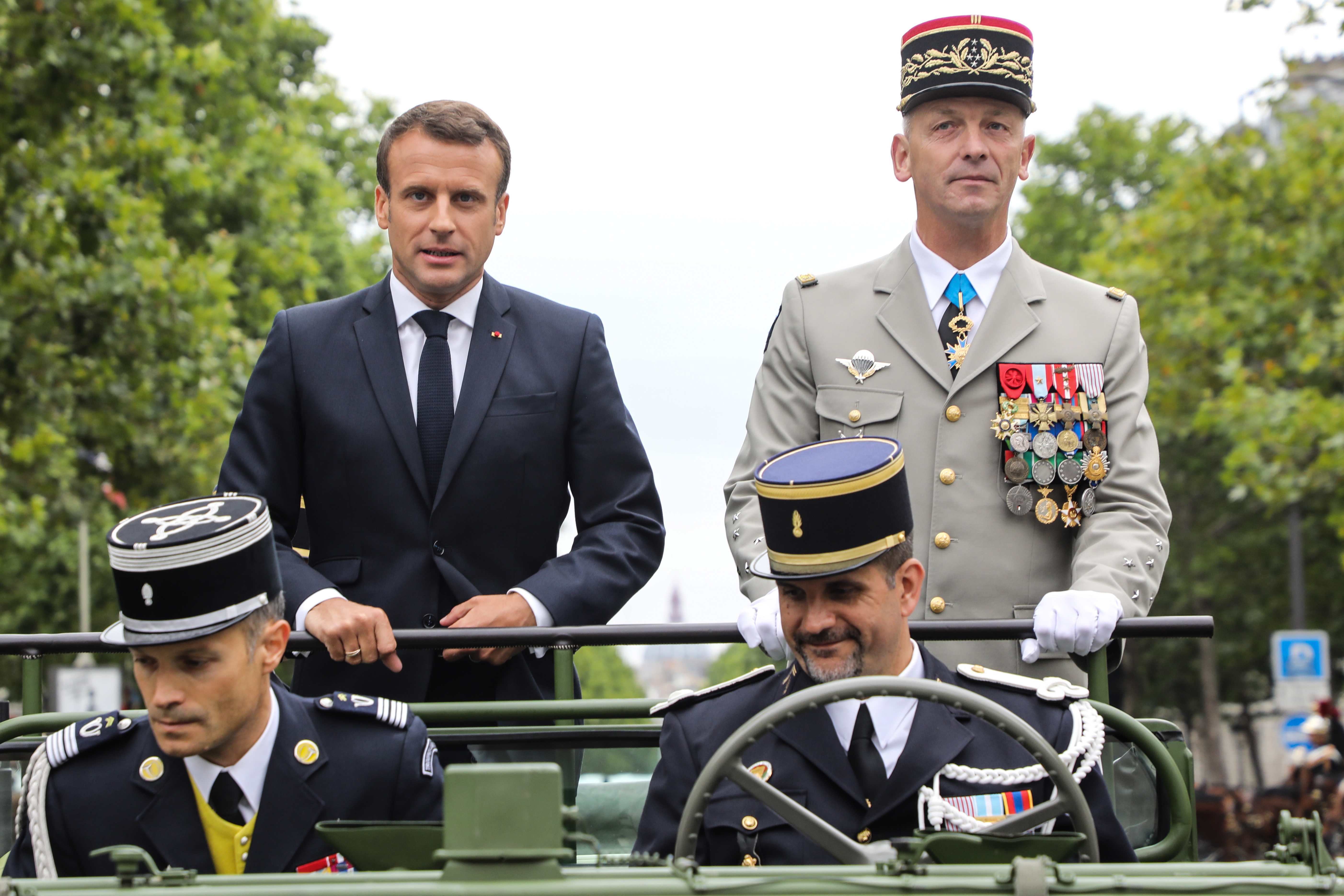 epa07715842 France's President Emmanuel Macron (L) stands in an Acmat VLRA vehicle next to French Armies Chief Staff General Francois Lecointre as they review troops before the start of the Bastille Day military parade down the Champs-Elysees avenue in Paris, France, 14 July 2019.  EPA/LUDOVIC MARIN / POOL  MAXPPP OUT