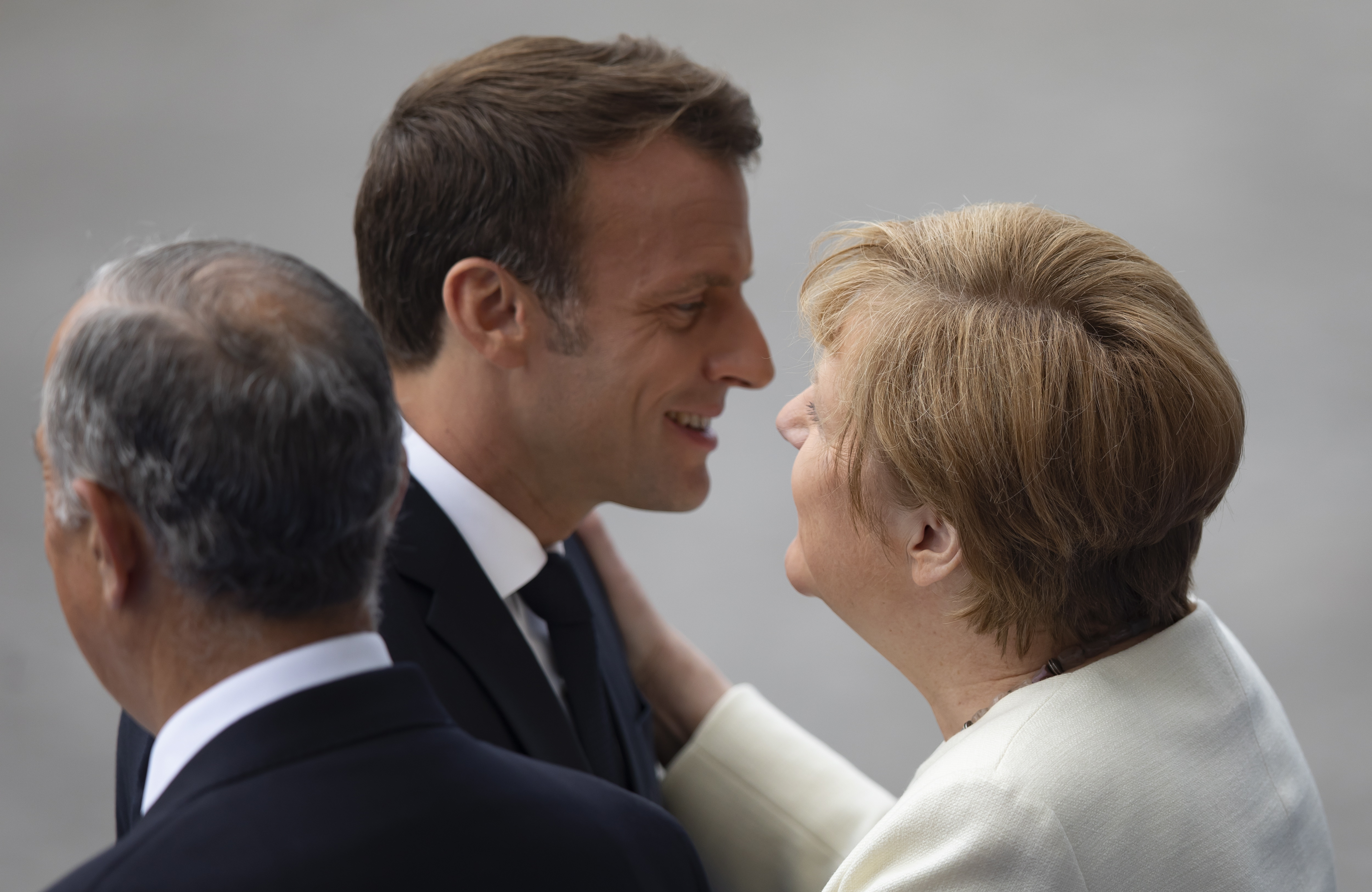 epa07716164 French President Emmanuel Macron (C) embraces German Chancellor Angela Merkel (R) as they attend the annual Bastille Day military parade on the Champs Elysees avenue in Paris, France, 14 July 2019 Bastille Day, the French National Day, is held annually on 14 July to commemorate the storming of the Bastille fortress in 1789.  EPA/IAN LANGSDON