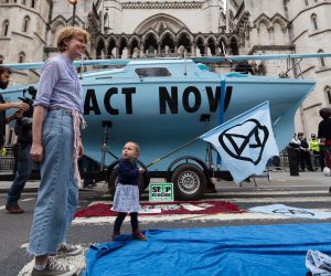 epa07718200 Environmental protesters in front of a blue boat belonging to Extinction Rebellion outside the Royal Courts of Justice this morning where Extinction Rebellion climate change protesters have blocked the road in London, Britain, 15 July 2019. Climate change protests are taking place across five UK cities this week in a series of 'Summer Uprising' actions that are calling for the government to act on cutting emissions.  EPA/VICKIE FLORES